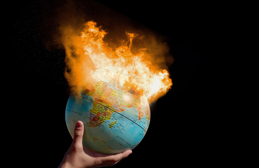 Concept of earth destroyed by pollution, global warming, greenhouse effect, destroying the planet, No planet B for the future generation. Burning planet in a child hand