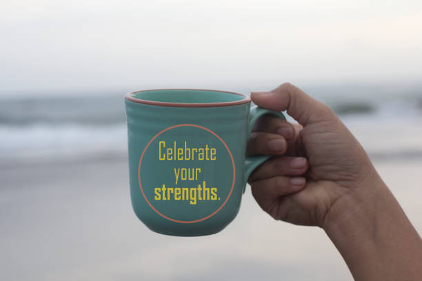 Message on a coffee cup in hand - Celebrate your strength. On beach background. Self empower concept.