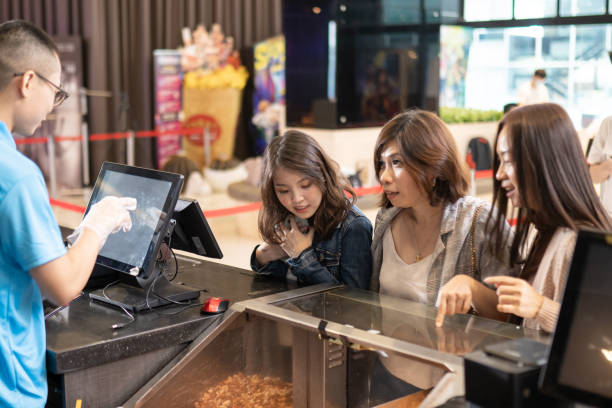 grupo de mujeres chinas asiáticas en el mostrador del bar delantero ordenando palomitas de maíz antes de la hora del espectáculo de cine en el cine de cine - cinta para caja registradora fotografías e imágenes de stock