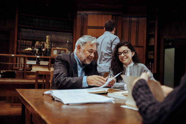 istock Senior professor working with female student in the library 1326822085
