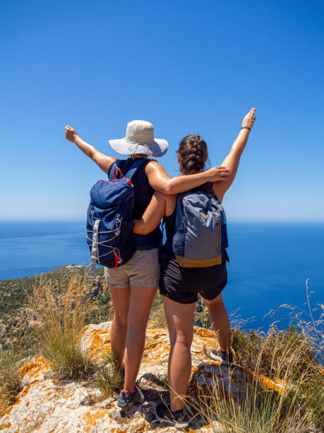 istock Back view of two happy friends after a successful hike 1326824461