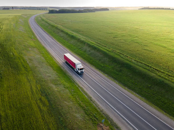 istock Pink Truck with Cargo Semi Trailer Moving on Road in Direction. Highway intersection junction. Aerial Top View 1326826765
