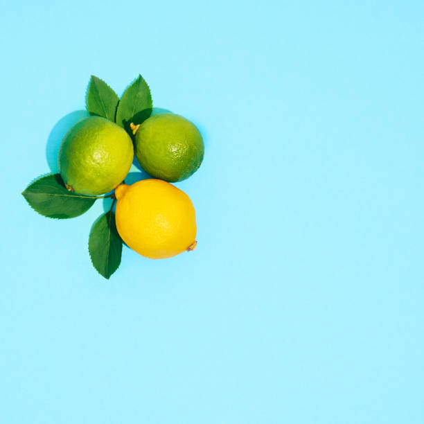 istock Fresh limes and lemons on blue background. 1326829723