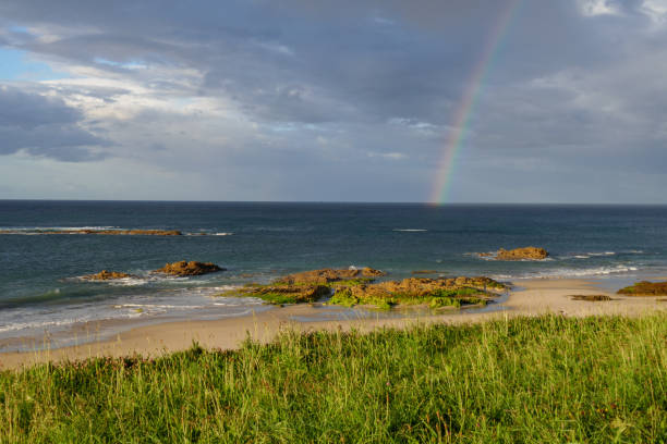 Rainbow in sea from Playa Llas in Foz, Lugo, Galicia. Beautiful colorful landscape. stock photo
