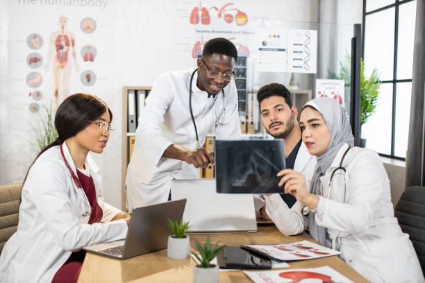 istock Multiethnic doctors analyzing x ray scan of patient lungs 1326831544