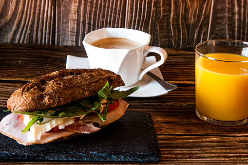 Breakfast with vegetable sandwich, tomato, mozzarella and ham plus coffee and orange juice