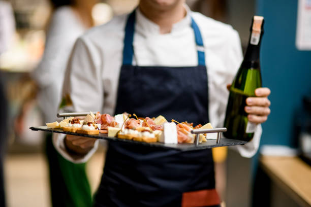 tray with different delicious snacks in the hand of the chef tray with different delicious snacks and pieces of cheese in the hand of the chef. Selective focus restaurant food canapes appetizers stock pictures, royalty-free photos & images
