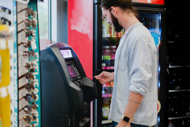 Young Man Using ATM Machine - fotografia de stock