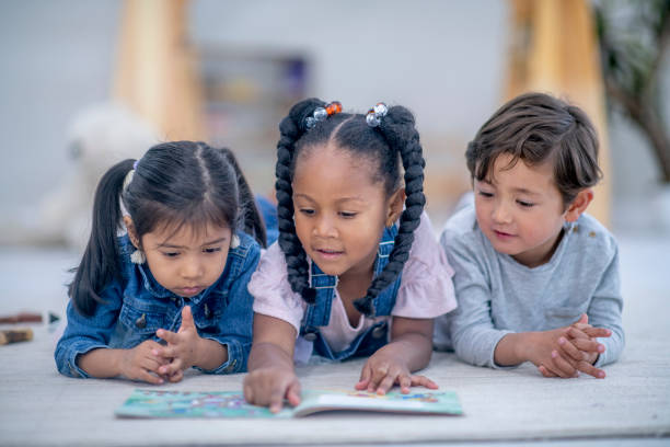 istock Multi ethnic preschool children reading a book together 1326840804