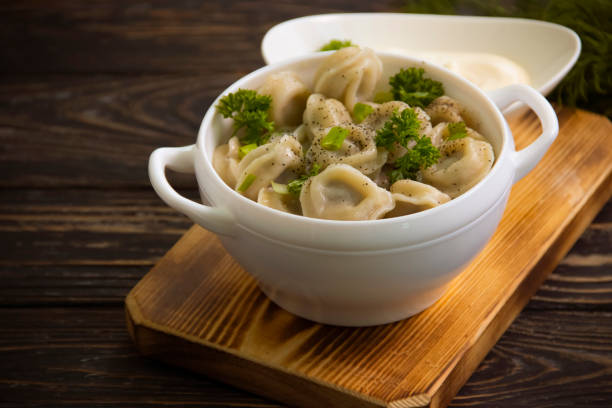 istock dumplings, dill on wooden background 1326842967