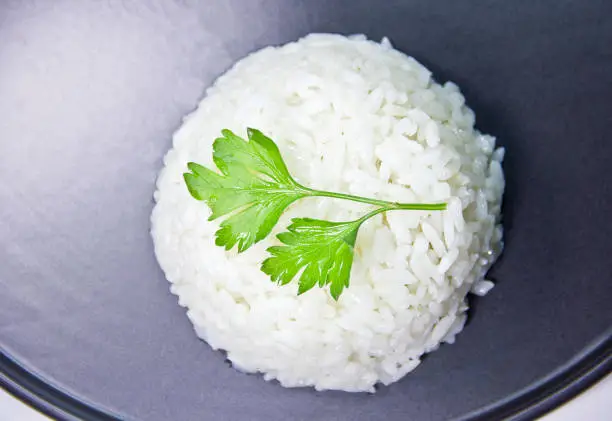 Cooked basmati rice served in a ceramic bowl or plate on white background.