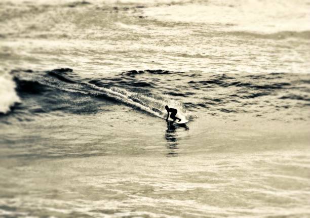 man surfing an average wave on a black and white background
