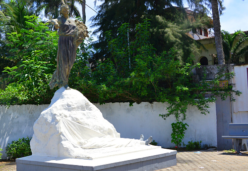 Grand-Bassam, Aboisso department, Sud-Comoé region, Comoé district, Ivory Coast / Côte d'Ivoire: Monument to the Dead, pays homage to the victims of the yellow fever epidemic which killed 2/3 of the colonists in Grand-Bassam in 1899. Sculpted by Alfred Lenoir, was inaugurated in 1914, it is surmounted by Marianne carrying a bouquet of flowers in her arms. The epidemic lasted until 1903, it explains why Grand-Bassam lost its status as capital to Bingerville in 1900. Boulevard Treich-Laplène, Quartier France - UNESCO world heritage site - 'Monument aux Morts français'.