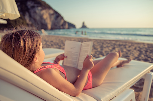 woman sitting on grass reading book