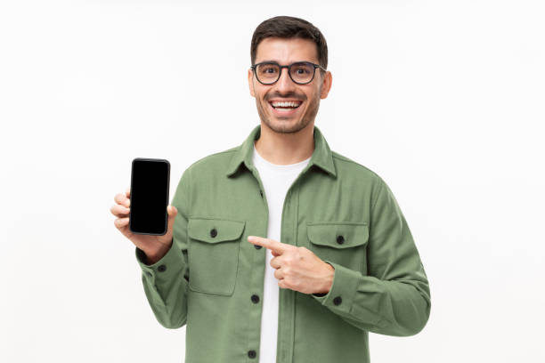 istock Happy laughing man showing with finger blank smartphone, smiling at camera, isolated on gray background 1326852413