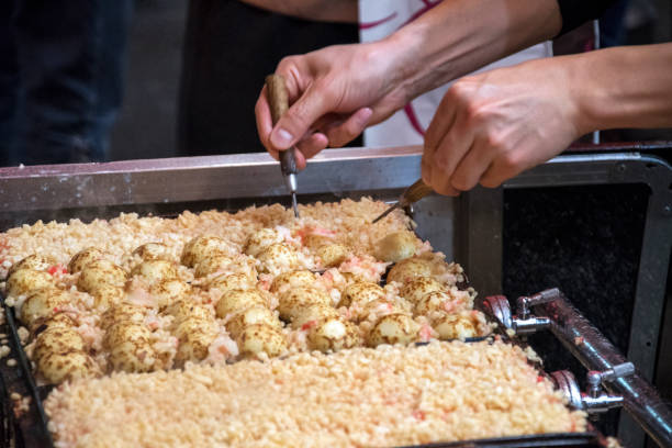 istock Vendor making takoyaki on a takoyaki pan in Osaka, Japan 1326852459