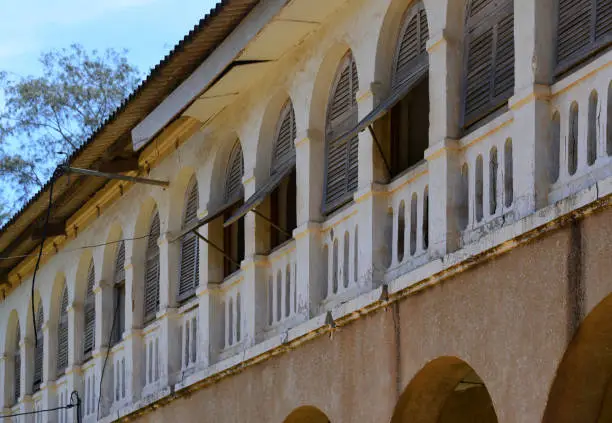 Grand-Bassam, Aboisso department, Sud-Comoé region, Comoé district, Ivory Coast / Côte d'Ivoire: old government building with arches and wooden shutters on Rue Bouët -  French colonial architecture of the Quartier France, Historic Town of Grand Bassam - UNESCO world heritage site.