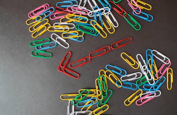 istock Selective focus.Colorful paper clips are arranged like arrows on a black background. 1326853628