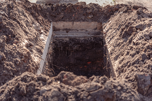 Fosa grave recién excavada en el cementerio, un primer plano photo