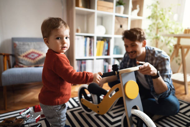 istock Father and son using balance bike at home 1326861889