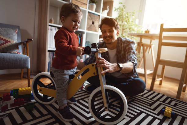 istock Cheerful dad and son playing and having fun with balance bike 1326861921