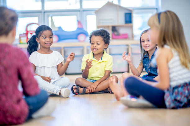 istock Multi ethnic elementary school children sitting in a circle together 1326865187