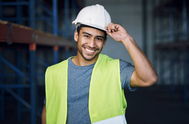 portrait d’un jeune homme confiant travaillant sur un chantier de construction - architect construction engineer standing photos et images de collection