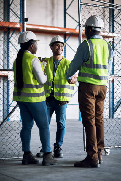 disparo de constructores estrechando la mano en un sitio de construcción - hardhat construction men handshake fotografías e imágenes de stock