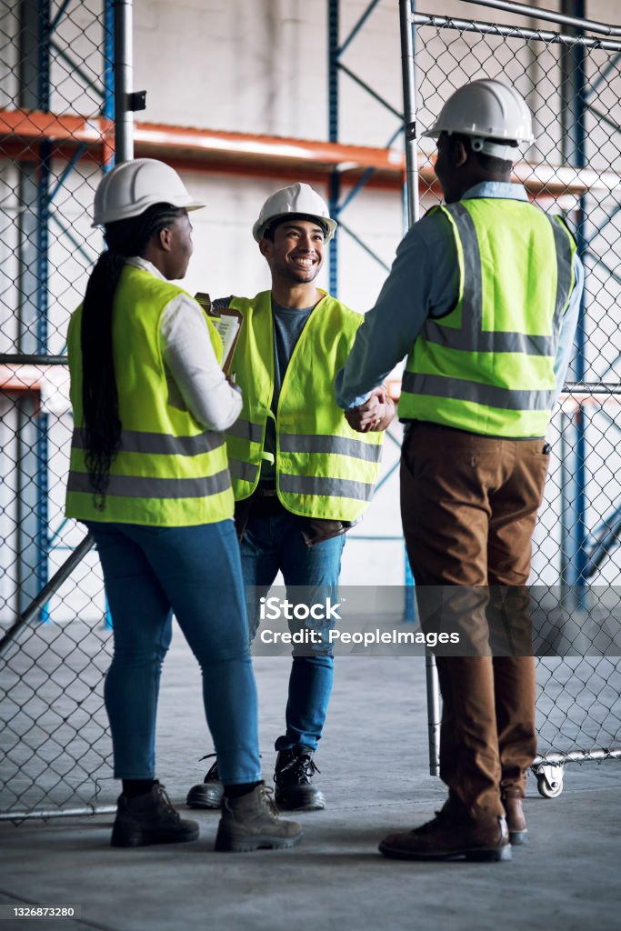 Shot of builders shaking hands at a construction site Shared experience is bound to pull off their project Occupation Stock Photo