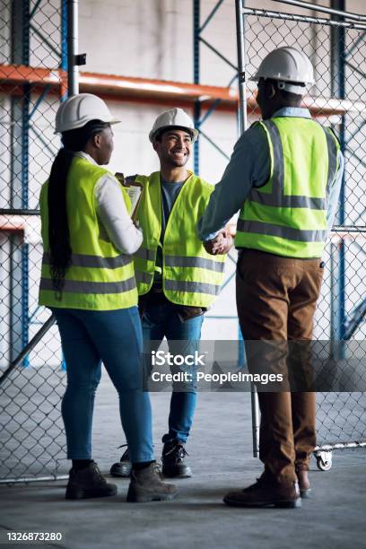 Shot Of Builders Shaking Hands At A Construction Site Stock Photo - Download Image Now