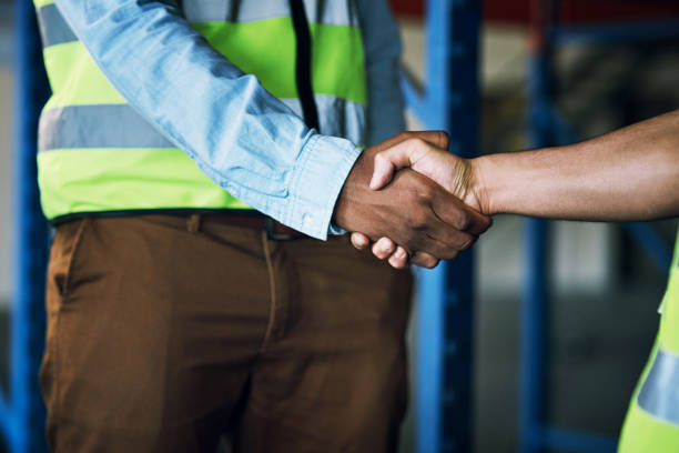 istock Shot of two builders shaking hands at a construction site 1326873283