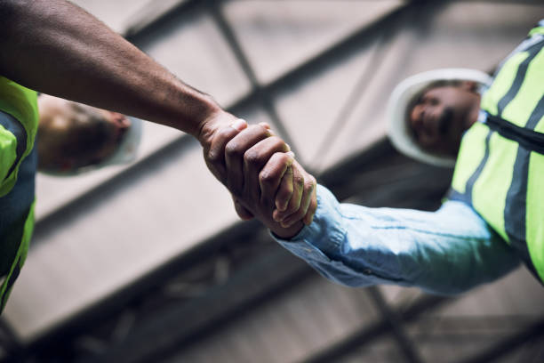 colpo di due costruttori che si stringono la mano in un cantiere - child building activity construction engineer foto e immagini stock