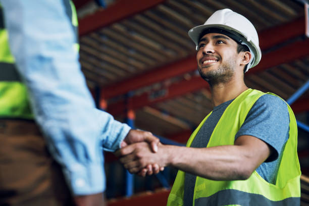 Shot of two builders shaking hands at a construction site Trust, respect and reliability, everything great partnerships are built on manual worker stock pictures, royalty-free photos & images