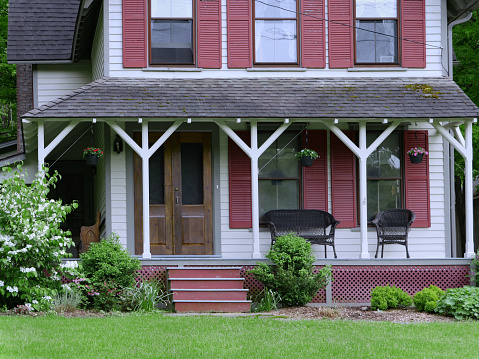 Pennsylvania, USA - May 27, 2019:  Large old fashioned porch of rural house, with wicker chairs