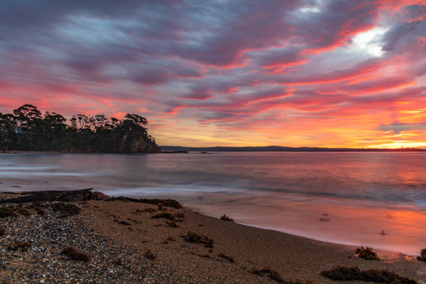 istock Cloud covered sunrise seascape tinged with pink 1326886800