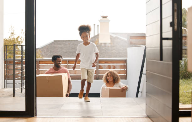 foto de una familia que lleva cajas a su nuevo hogar - home interior arrival father family fotografías e imágenes de stock