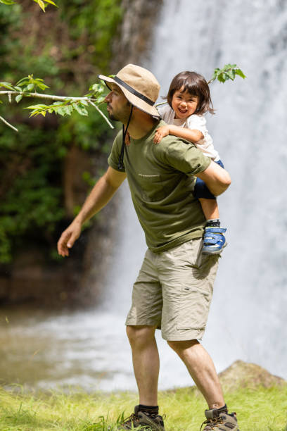 istock Father hiking with young daughter on his back in nature 1326888545