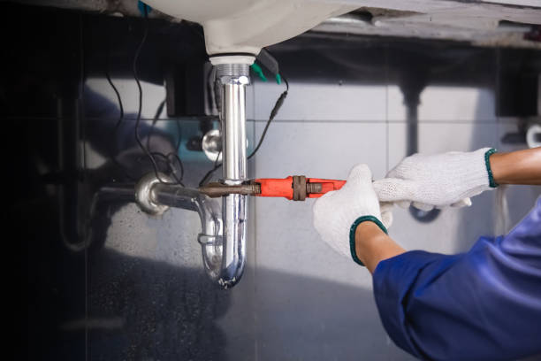 istock Plumber fixing white sink pipe with adjustable wrench. 1326896498