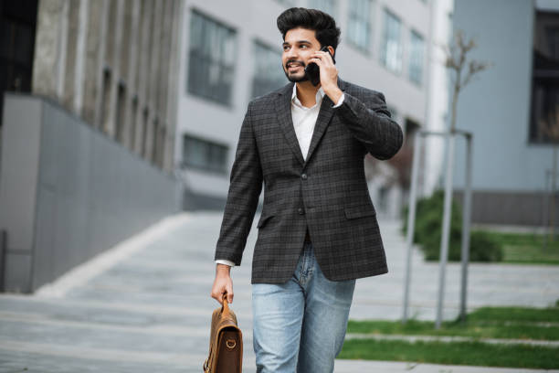 istock Arabian entrepreneur walking on street and talking on mobile 1326899699