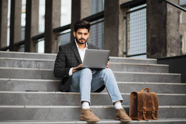 istock Arabian man sitting on stairs and working on laptop 1326900600