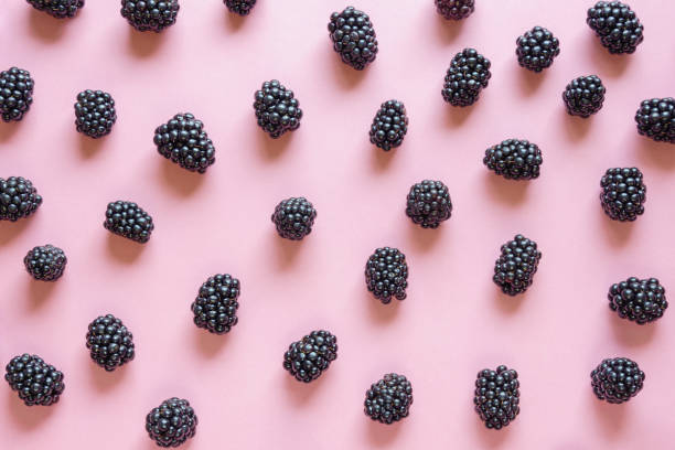 istock Fresh ripe blackberries on pink paper background 1326901472