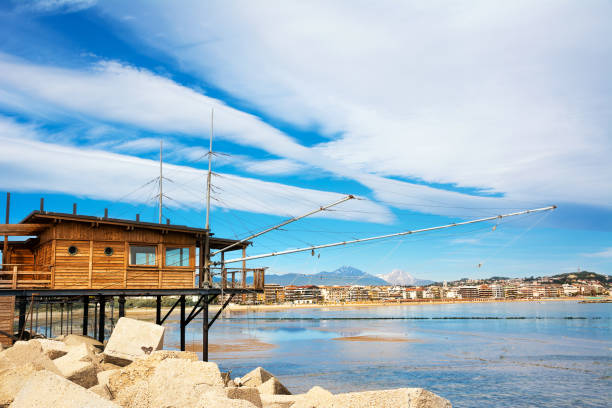 trabucco al porto, com vista para a orla de pescara, com a torre do sino da igreja divino amore e a montanha gran sasso - trebuchet - fotografias e filmes do acervo