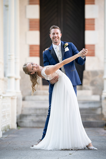 elegant beautiful wedding couple in dancing pose smiling at camera