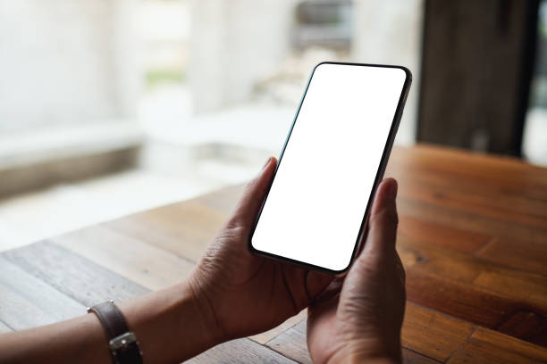 istock a woman holding mobile phone with blank white desktop screen 1326912814