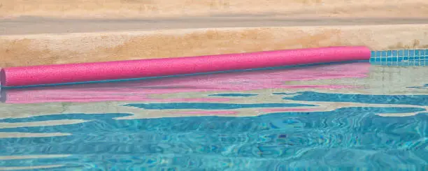 Pink floating snake with abstract  pink water ripples. Stock Image.