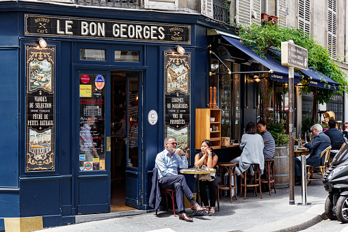 Paris, France - June 16, 2017: Parisians and tourists eating and drinking on the terrace of the traditional outdoor Parisian bistro Le Bon Georges.