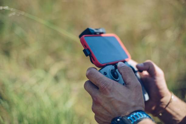 istock Man using remote control to operate his drone and taking photos 1326920463