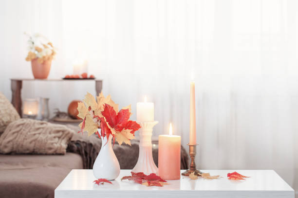 istock burning candles with autumn decor on white table at home 1326920666