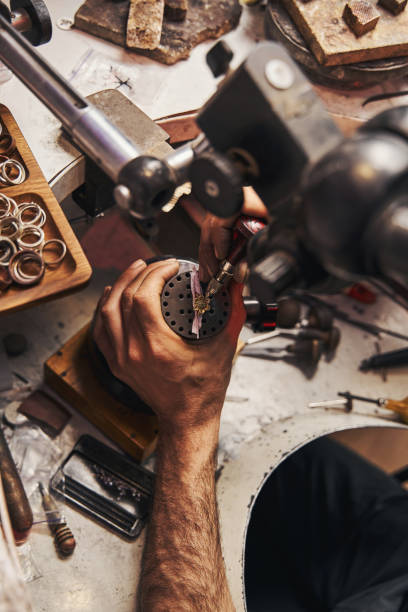 istock Jeweler using instrument for stone setting on flower ring 1326921940