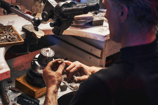 istock Goldsmith putting on ring on his finger 1326921947